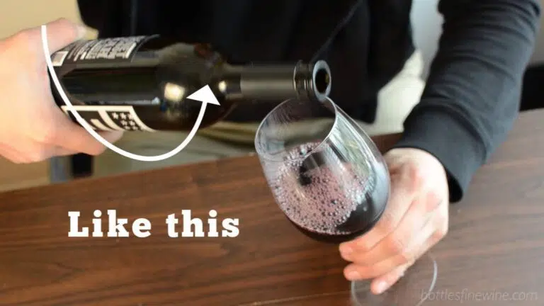 pouring a bottle of red wine into a glass