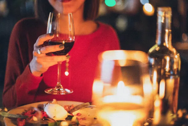 A lady holding a glass of wine on a date